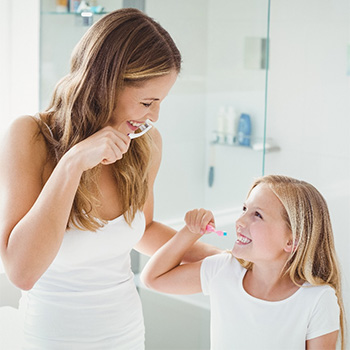 mom and daughter brushing teeth