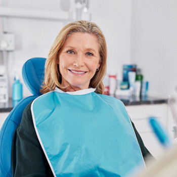a smiling woman sitting in a dental chair