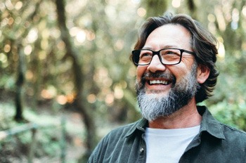 a smiling man taking a walk outside