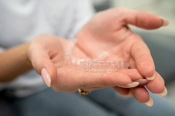 Closeup of patient holding clear aligner
