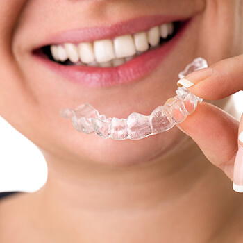 woman holding invisalign