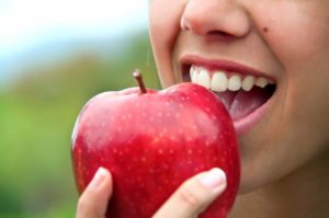 close up of a person about to eat apple