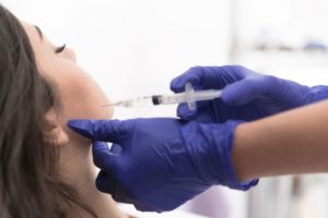 Patient receiving BOTOX injection near her jaw