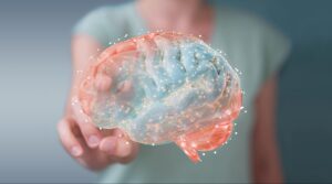 Woman blurry in the background touching fingers to an animated colorful brain in the foreground