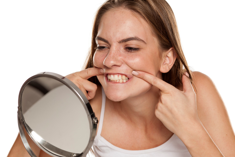 Patient smiling in the mirror after getting porcelain veneers