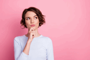 Woman tapping her chin and looking slightly upwards in a questioning pose